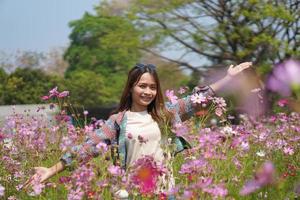 Happy Asian woman in cosmos flower garden photo