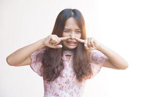 Asian woman covering her nose with her finger from the stench photo