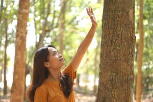 concept of saving the world Asian woman touching a tree photo