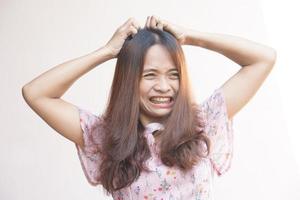 Asian woman has an itchy scalp from dandruff. photo