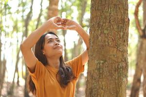 concept of saving the world Asian woman looking at the tree photo