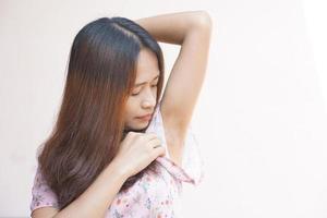 asiático mujer huele de húmedo axilas foto