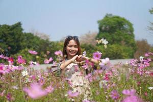 contento asiático mujer en cosmos flor jardín foto