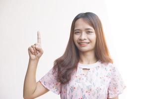 asiático mujer señalando dedo a lado foto