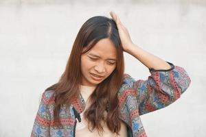 Asian woman has an embarrassment headache from work photo