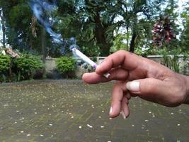 hand holding a lit cigarette photo