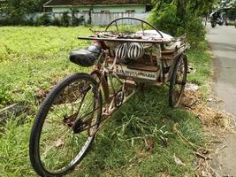 an old rickshaw was parked at the edge of the rice fields photo