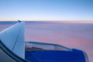 puesta de sol visto desde un avión ventana, con un ver terminado el ala y motor. foto