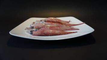 Squid Seafood on a plate on a black background. photo