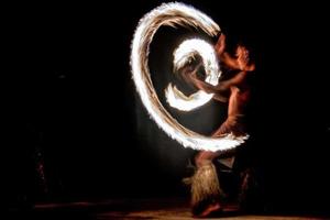 Fire dance Cook Islands polynesian dancer with pole of flames photo