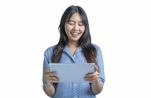 Photo of an attractive young woman holding pc tablet reading and browsing news information isolated over white color background. Smiling woman in studio standing and using a digital tablet.