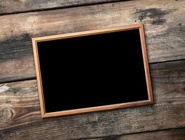 rectangular brown wooden frame on a background of very old boards photo