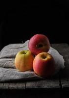 bunch of fresh red apples lies on a gray linen napkin photo