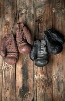 two pairs of leather vintage boxing gloves hanging on a nail photo