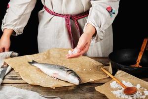 fresh whole sea bass fish lying on brown paper photo