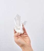 female hand holding a clean white paper napkin for face and body photo