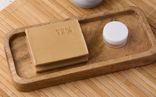 Rectangular brown laundry bar of soap on a wooden background, top view photo