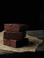 stack of baked square pieces of chocolate brownie cake photo