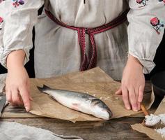 fresh whole sea bass fish lying on brown paper photo