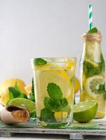 summer refreshing drink lemonade with lemons, mint leaves, lime in a glass photo