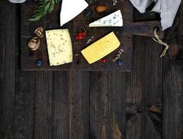 cheese on a brown cutting board roquefort, brie, cheese with walnuts photo