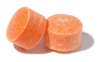 Two round orange tablets on a white isolated background, vitamin C photo