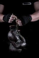 pair of very old boxing sports gloves in men's hands photo