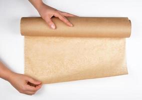 roll of brown parchment paper in female hands photo