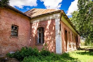 Beautiful old abandoned building farm house in countryside on natural background photo