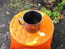 The iron cup on the orange plastic chair photo