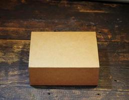 Blank Small Cardboard box on wooden background photo