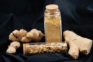 fresh ginger and dried ginger powder on olive wood photo