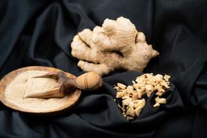 fresh ginger and dried ginger powder on olive wood photo