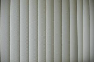 Blinds are white. Vertical blinds on window. Light from window. photo