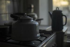 Kettle in kitchen. Water kettle. Darkens indoors. photo