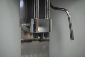 Coffee machine in detail. Coffee serving system. Supply of hot water jet for brewing drink. photo