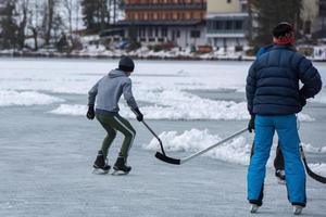 people playing hockey on frozen lake photo