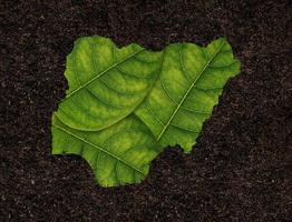 Nigeria map made of green leaves on soil background ecology concept photo