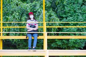 A female fan in a medical mask and sits alone in an empty stadium. Cancellation of sporting events during the coronavirus. One man army concept. photo