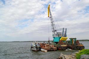 Luffing crane at the barge on water photo