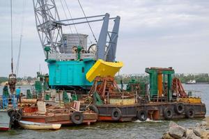 Luffing crane at the barge on water photo