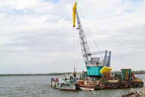 orzando grua a el barcaza en agua foto