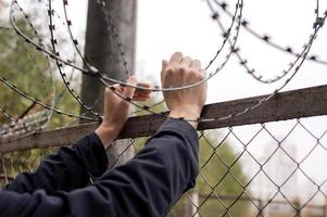 Men's hands on the background of barbed wire photo