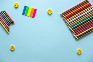 A set of bright stationery on a blue background. colored pencils and stickers photo