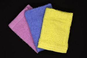 Terry towels on a dark background. Colorful wiping cloths. Terry napkins. photo