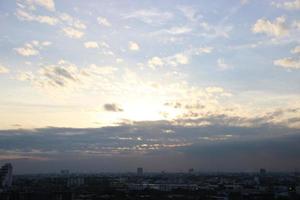 sunset dark blue cloud with white golden light sky background and city light midnight evening time photo