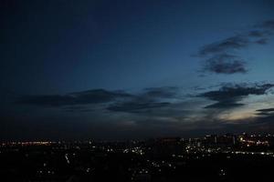 puesta de sol oscuro azul nube con blanco dorado ligero cielo antecedentes y ciudad ligero medianoche noche hora foto