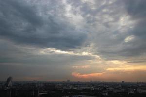 sunset dark blue cloud with white golden light sky background and city light midnight evening time photo