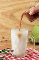 Pour Liquid Palm Sugar to Es Kelapa Muda, Young Coconut Ice photo