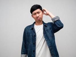 Young man jeans shirt scratch head feels doubt and confused isolated photo